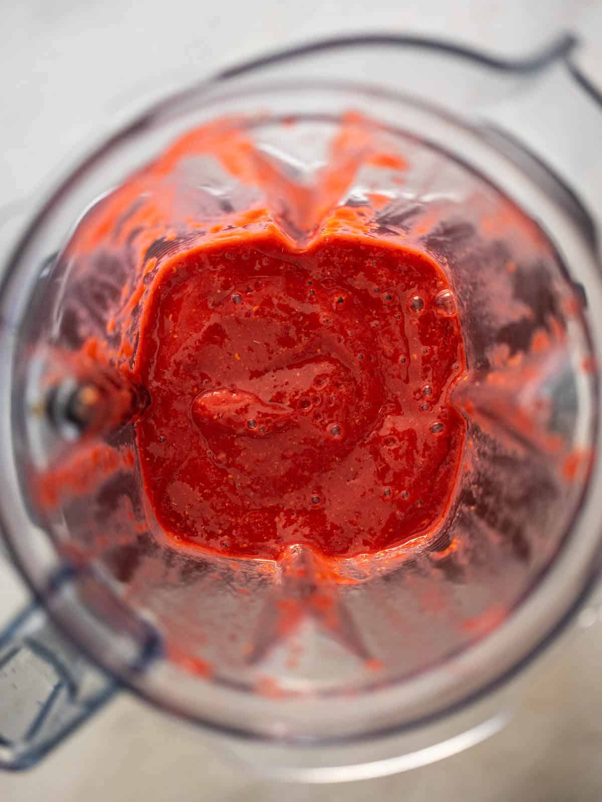 blender's jar with blended raspberry dressing.