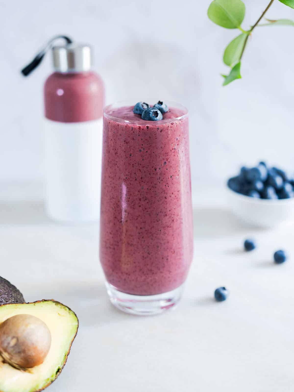 blueberry smoothie glass with a portion behind stored in a BPA free portable smoothie bottle.