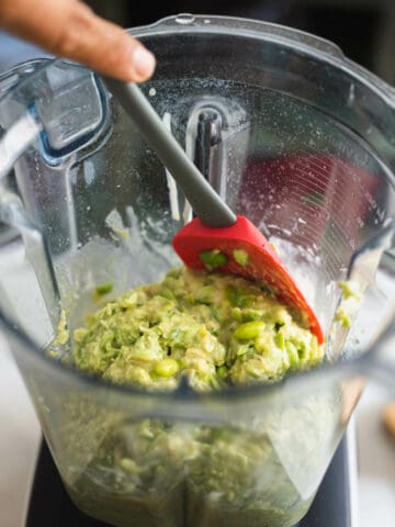 scraping the edges of the blender's with a spatula.