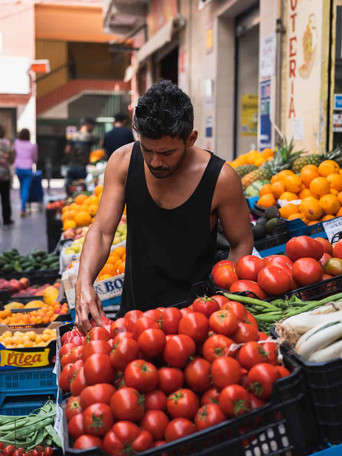 picking ripe tomatoes in farmers' market.