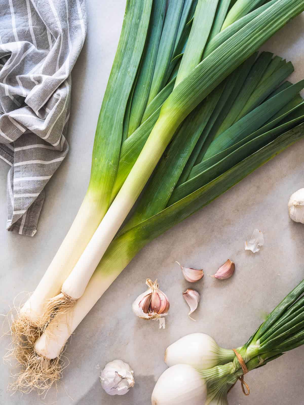 Leeks with onions and garlic as leek substitutes on a table. 