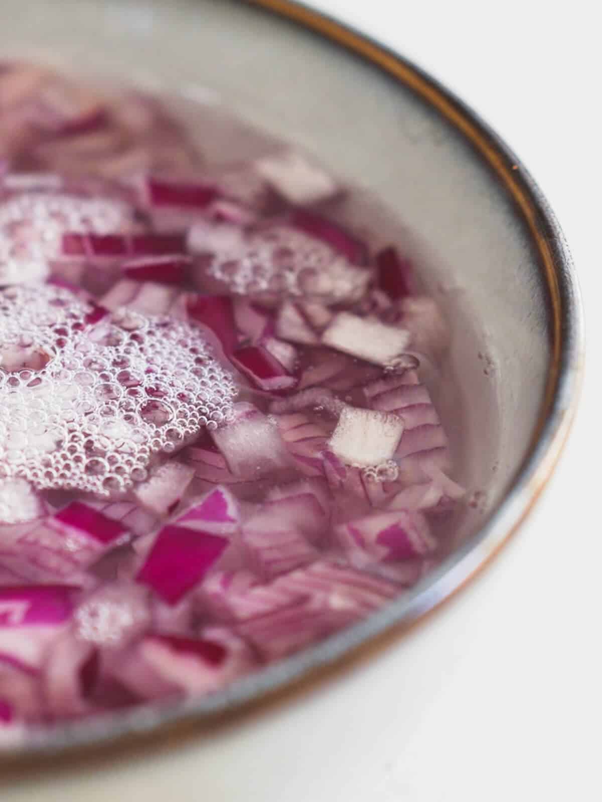 red onions soaking in water an vinegar.