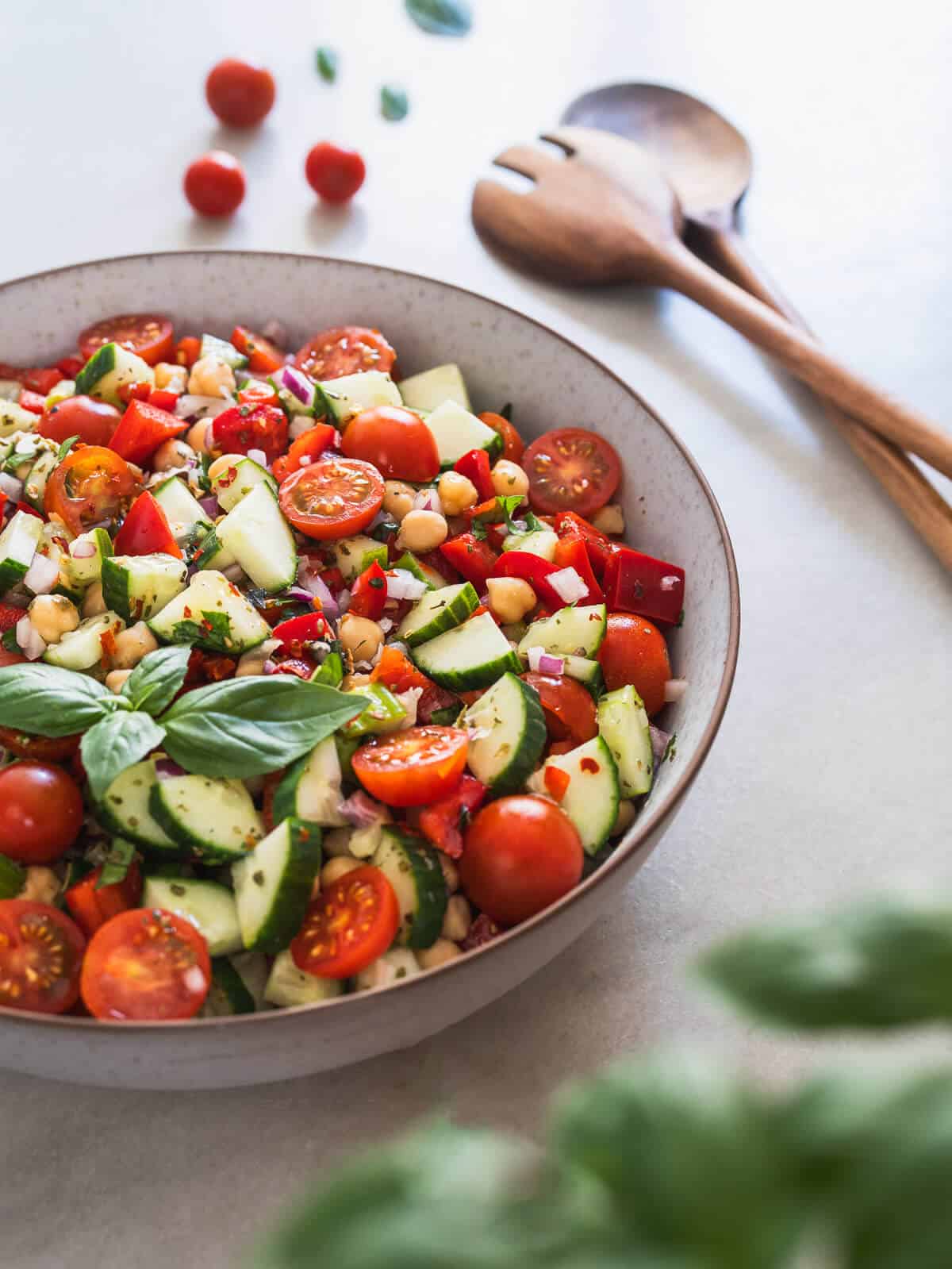 chickpeas and cucumber salad with serving spoons.