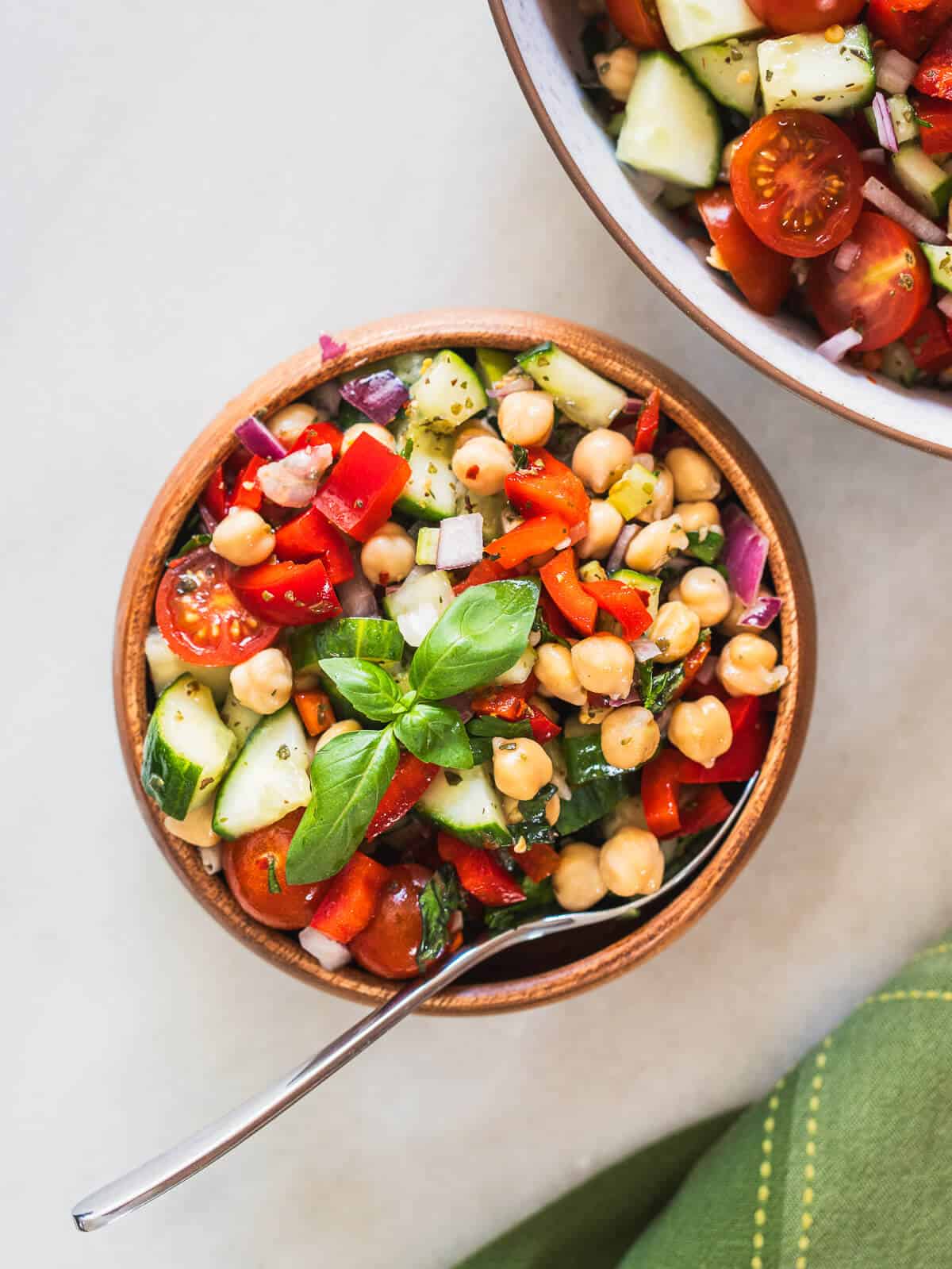 wooden bowl with mediterranean salad and a scooping spoon.