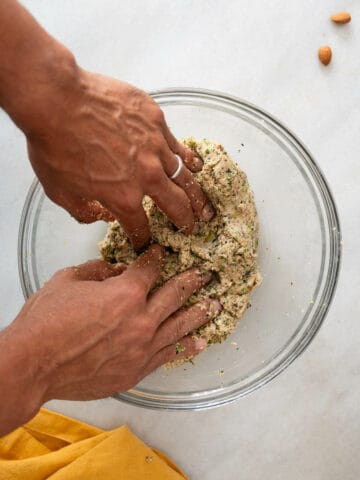 combining wet and dry ingredients with the hands in a mixing bowl.