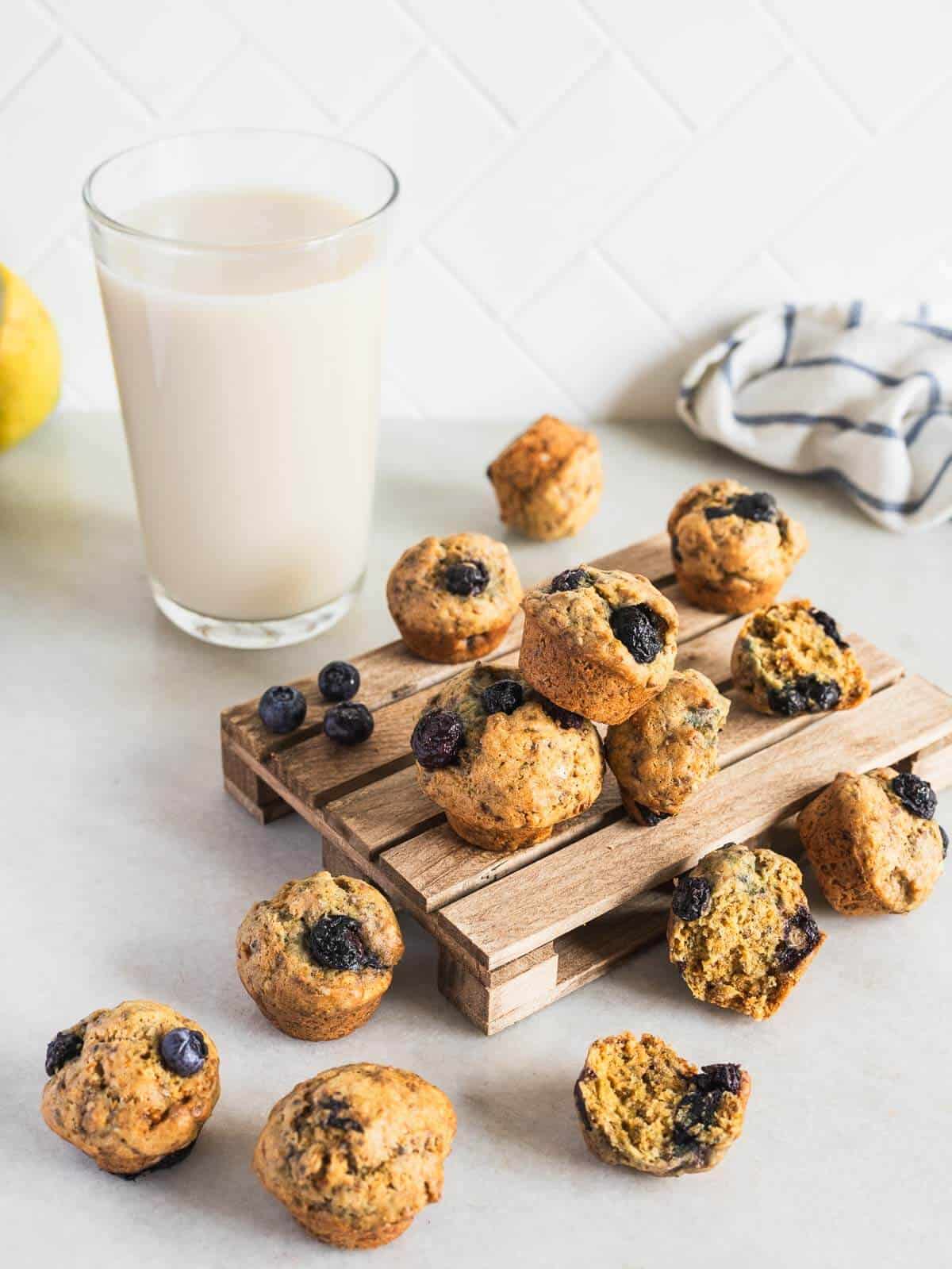 mini pallet with blueberry mini muffins and glass of milk.