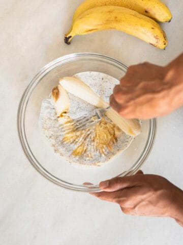 mashing bananas over the chia seeds and vegan buttermilk mix.