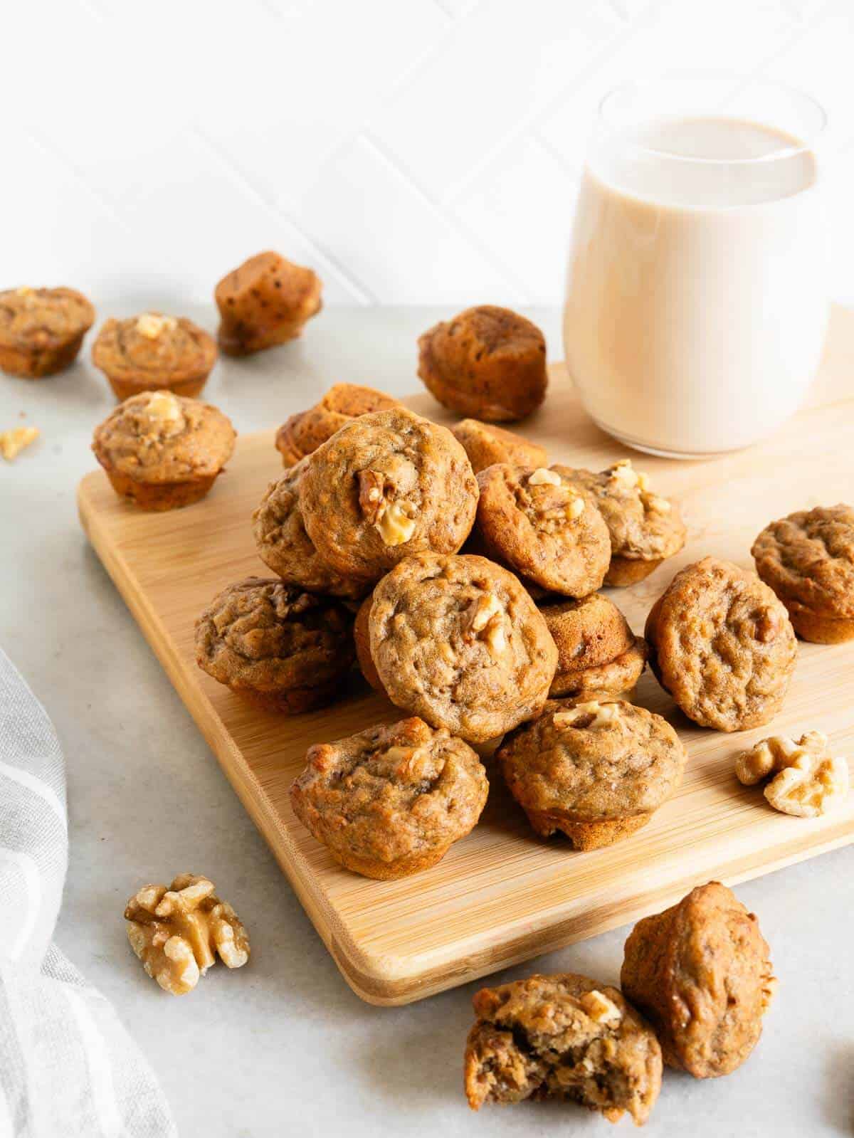 bunch of mini banana bread muffins with a glass of dairy-free milk.