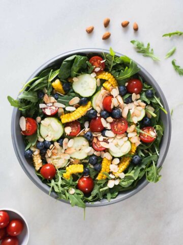 spinach and arugula salad with blueberry in a serving bowl.