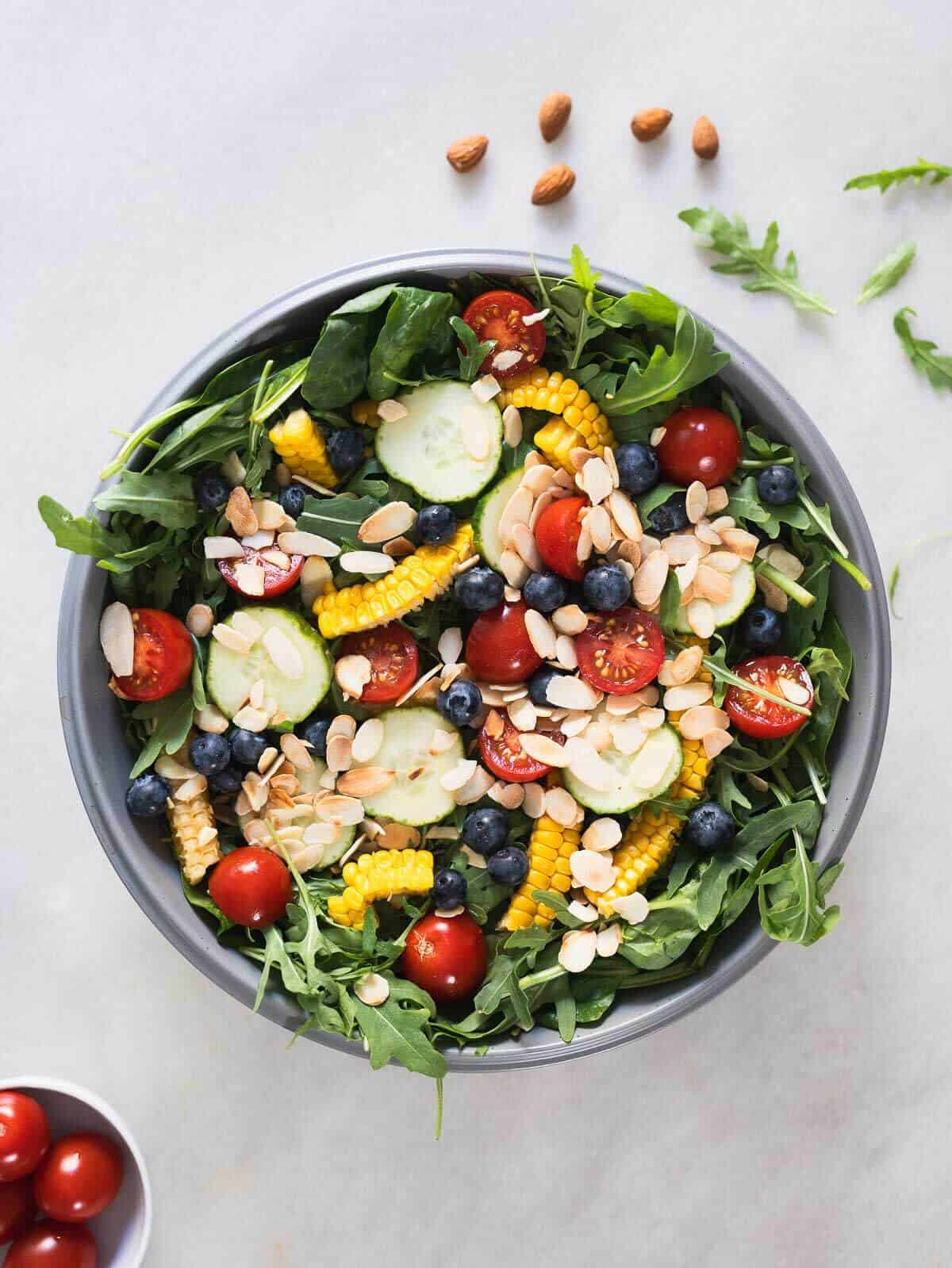 spinach and arugula salad with blueberries in a serving bowl.