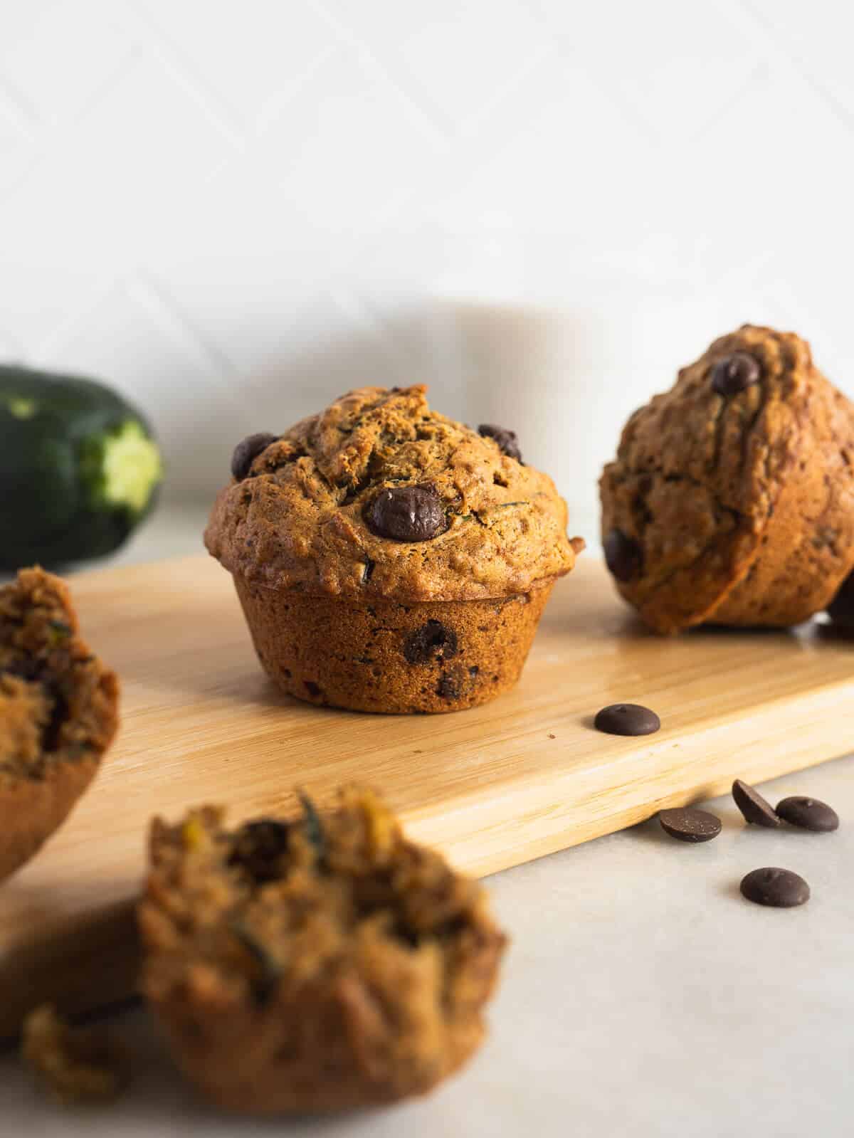 vegan chocolate zucchini muffins on a wooden table.