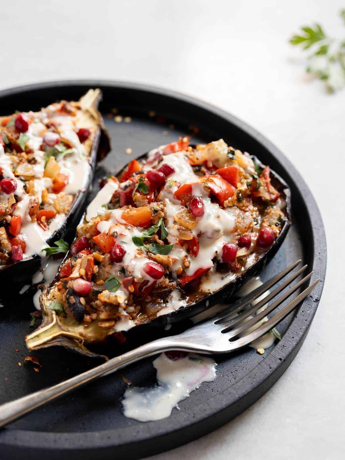 baked stuffed eggplants with tahini sauce and pomegranate seeds.