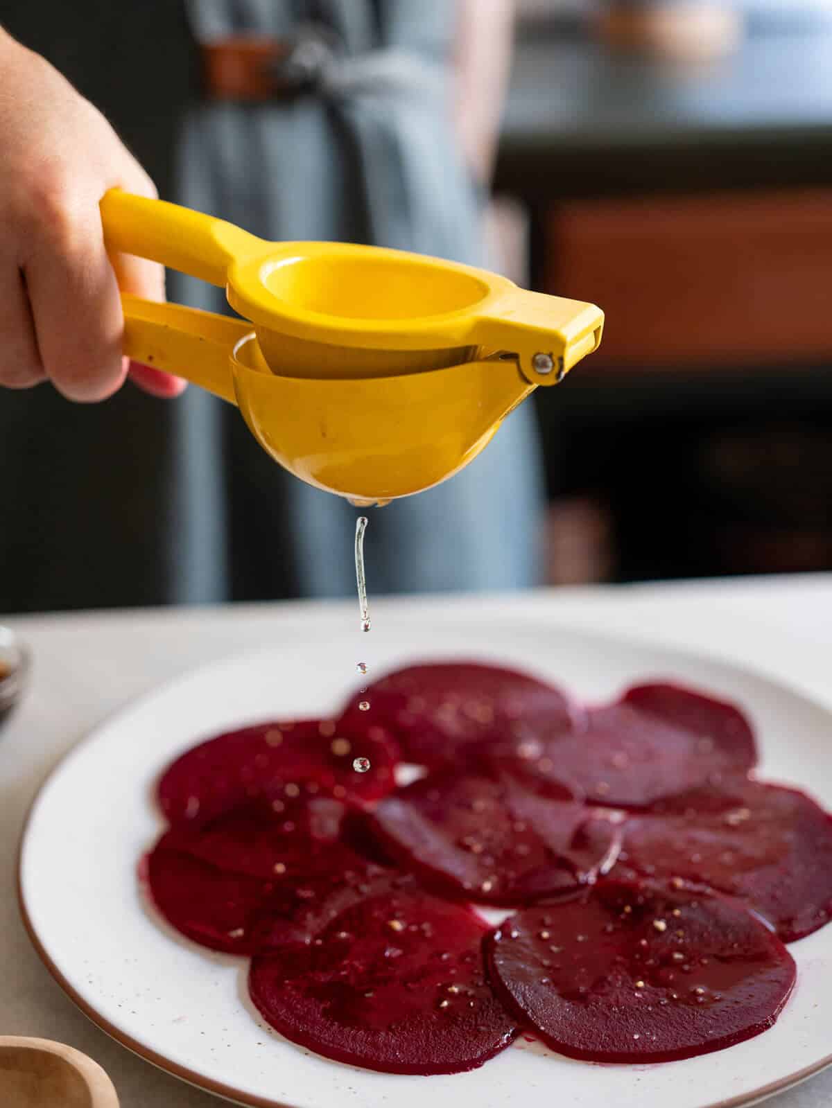 squeezing lemon into the greens salad bowl.