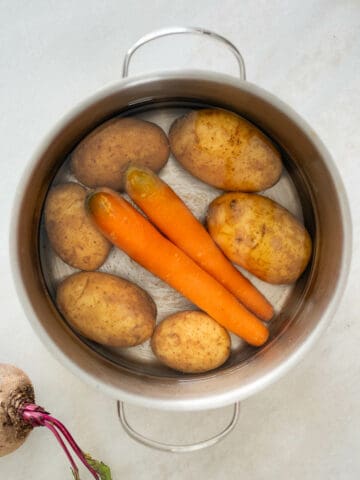 boiling potatoes and carrots in a saucepan.