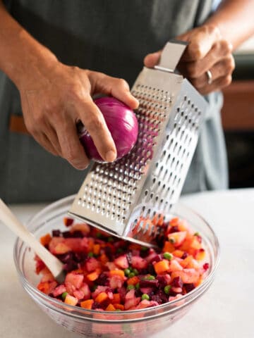 shred the red onion on top of the combined veggies.