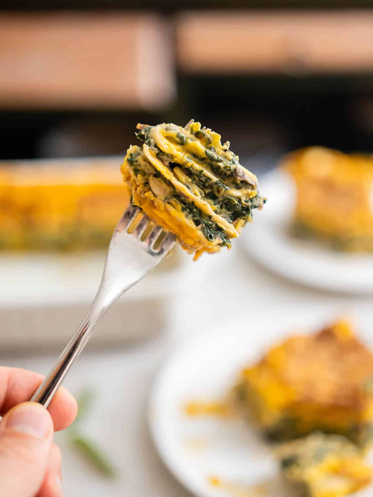 bite of vegan butternut squash spinach lasagna in a fork.