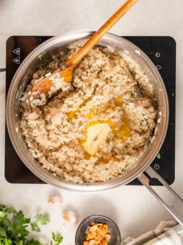 adding butter to the garlic risotto.