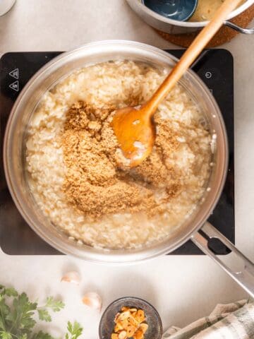 adding parmesan cheese to the risotto.