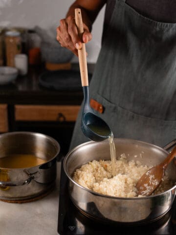 add stock to the garlic risotto.