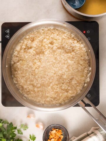 add chopped garlic followed by arborio rice and add vegetable stock only when the liquid is consumed.