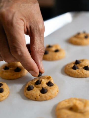 adding chocolate chips on top of cookies before baking.