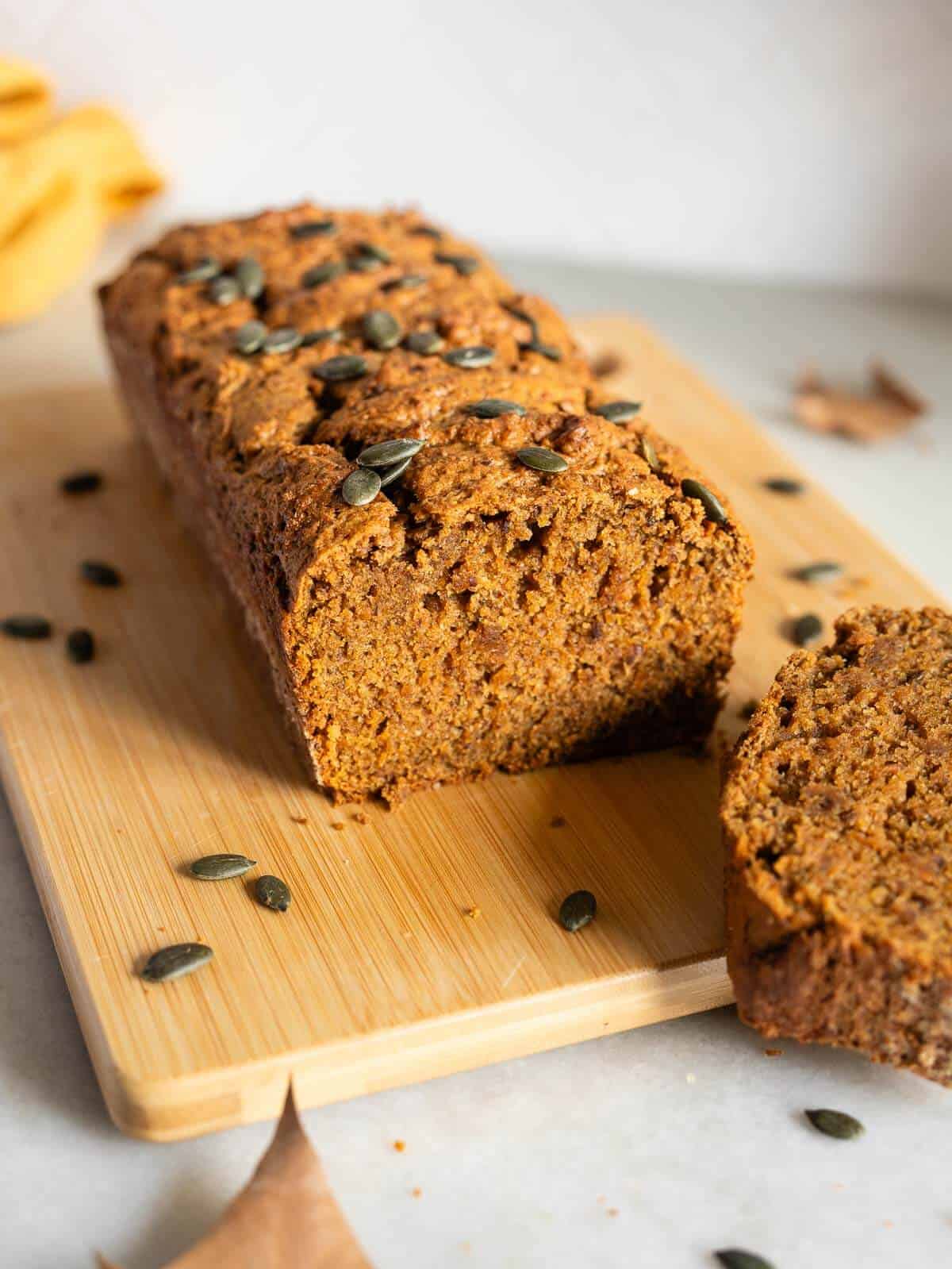 pumpkin spice loaf cake with pumpkin seeds on top.