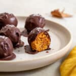 chocolate-covered pumpkin protein balls in a plate.