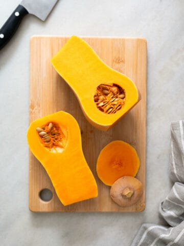 remove the top and bottom of the squash and half it with a knife.