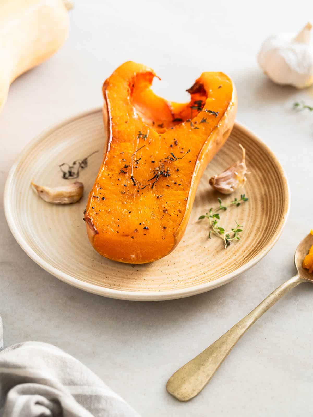 whole roasted butternut squash served in a white plate..