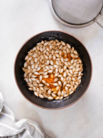 soaking squash seeds in water to remove filaments.