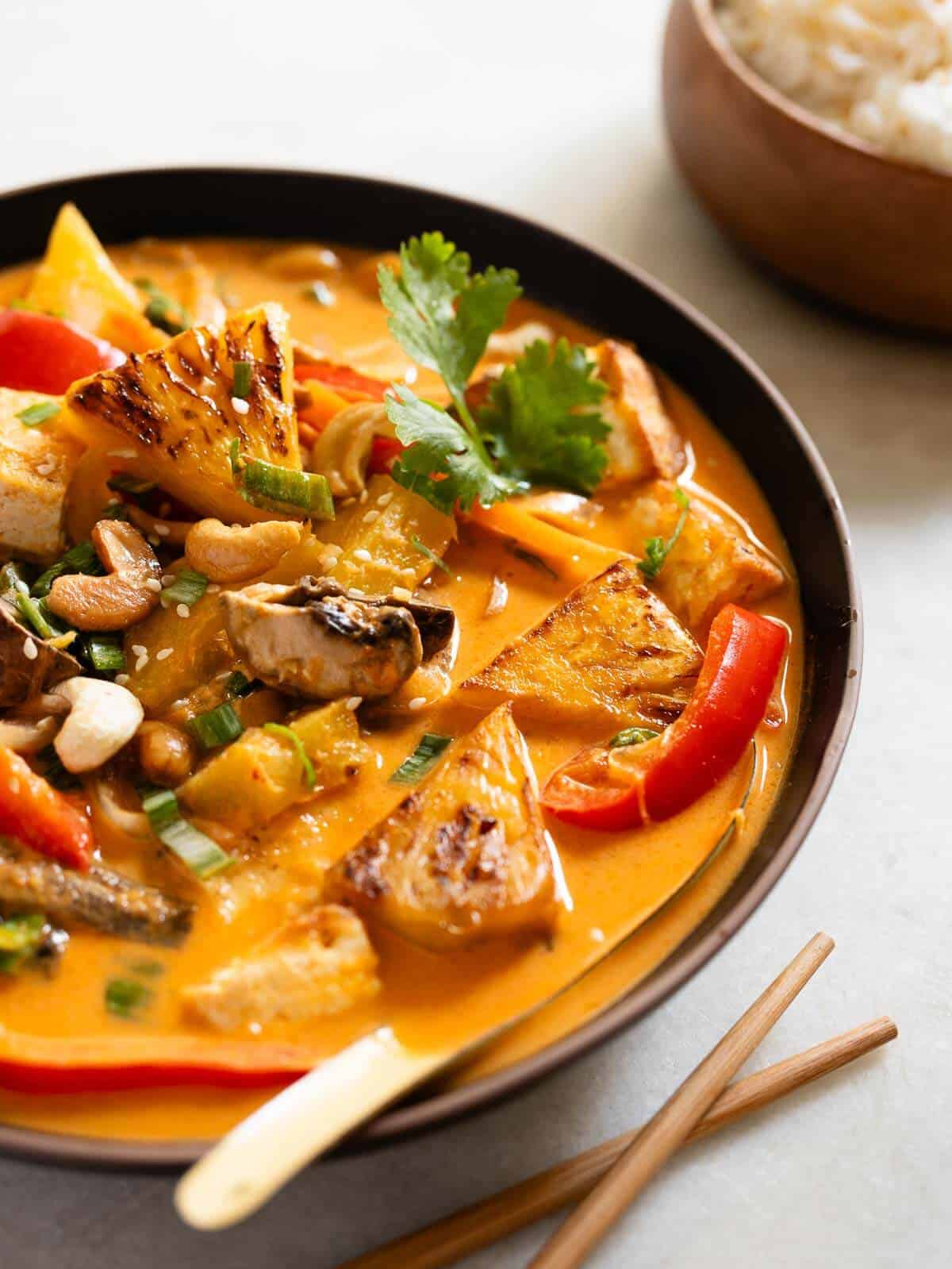 bowl served with coconut pineapple curry and chopsticks.