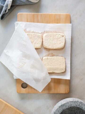 four tofu layers between paper towels.