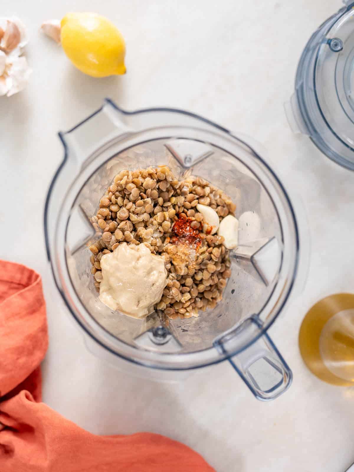 all the ingredients to make the lentil dip on a blender's vase.