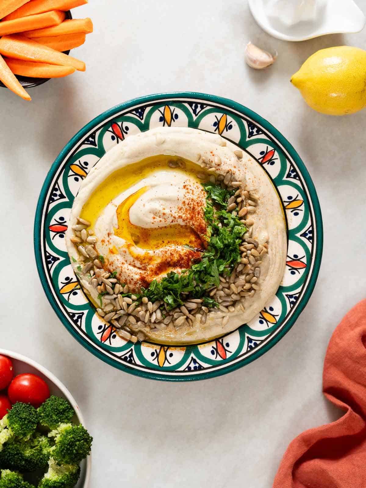 green lentil hummus on a middle eastern decorated serving plate.