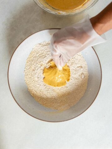 coating an oyster mushroom with the dry mixture, using a kitchen glove.