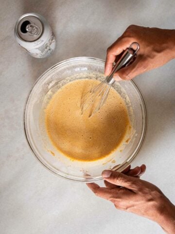 adding beer to one of the dry mixtures to make a batter.