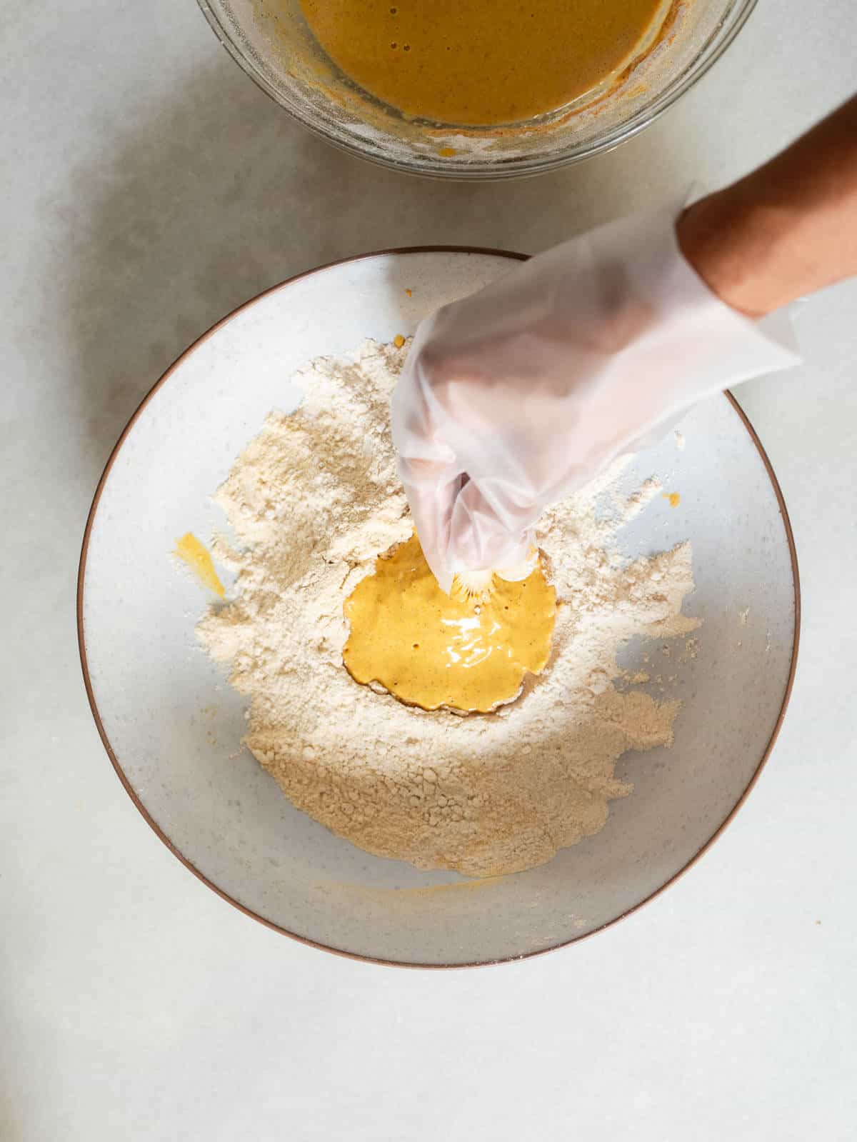 coating an oyster mushroom with the dry mixture, for the second time, using a kitchen glove.