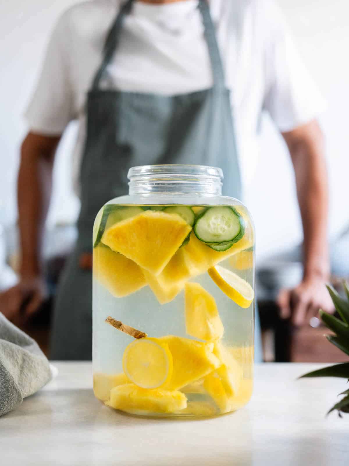 large pitcher with pineapple ginger cucumber lemon water ready to be put to chill in the fridge.