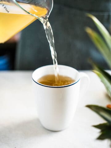 pouring pineapple tea into a cup.