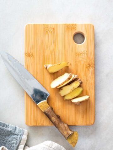 sliced ginger on a chopping board.