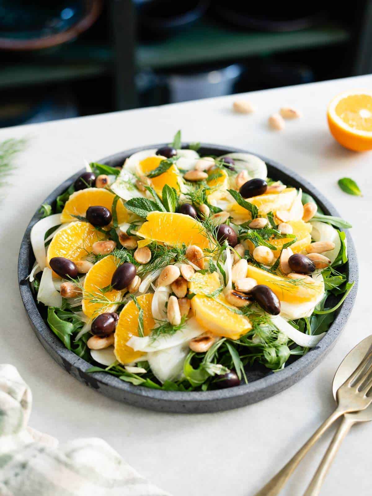 topping the salad with toasted almonds and black olives.
