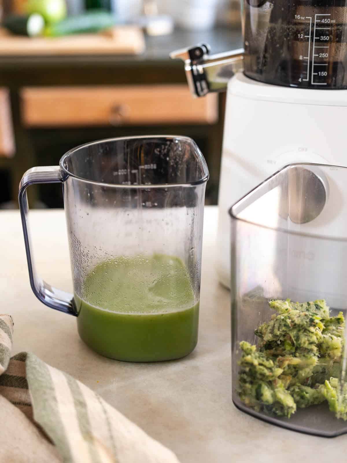 one container with green juice and another with the juice pulp.