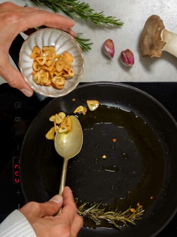 removing toasted garlic flakes with a spoon.