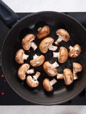 stir-frying mushrooms in a skillet.