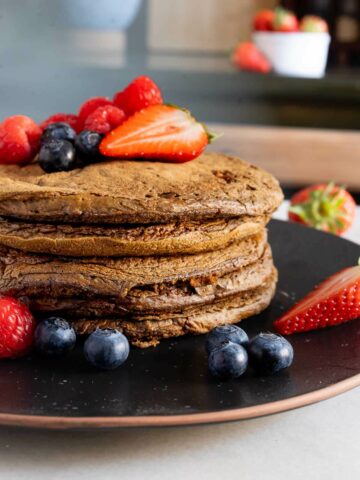 inger matcha pancakes topped with red berries.