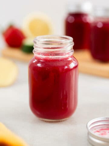 shot glass filled with juice for bloating.