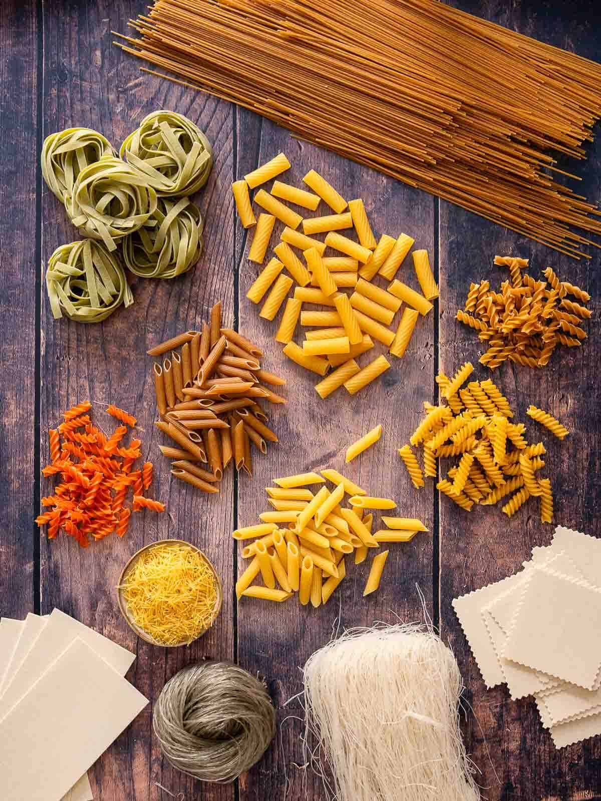 wooden table showcasing an array of different types of noodles.