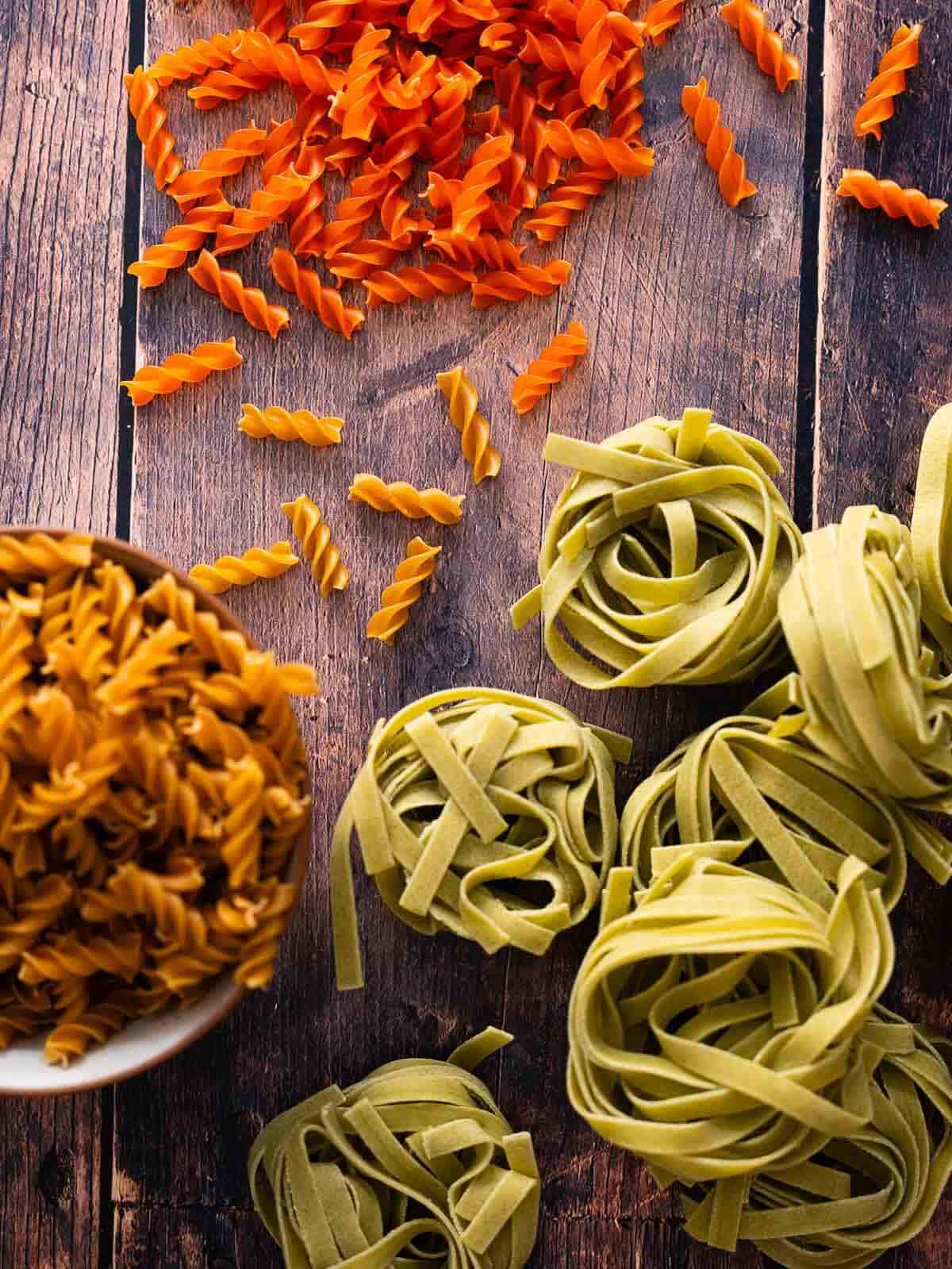 wooden table showcasing an array of alternatives types of pasta noodles such as spinach, chickpea, and red lentil fusilli.
