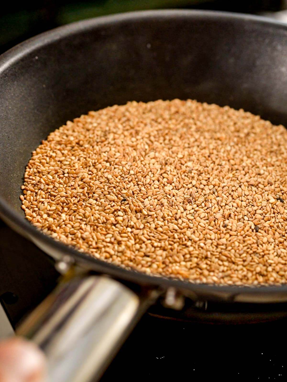 Toasting sesame seeds in a skillet.