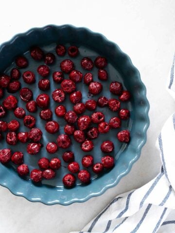 Pie Pan with Frozen Cherries - Frozen cherries arranged in a single layer in a pie pan.